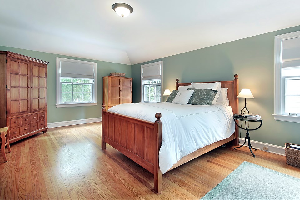 spacious primary bedroom with gorgeous hardwood floors.